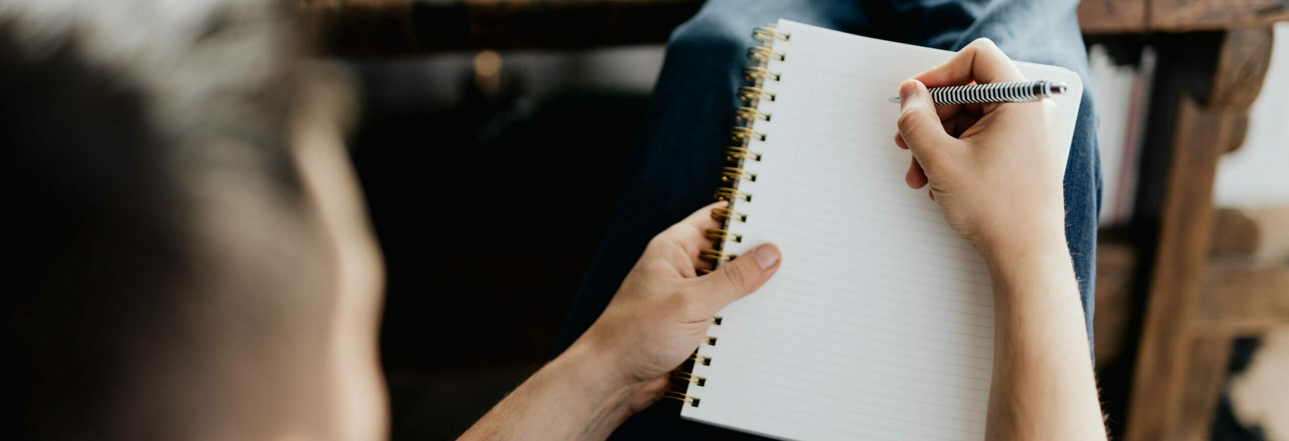 man writing on a piece of paper